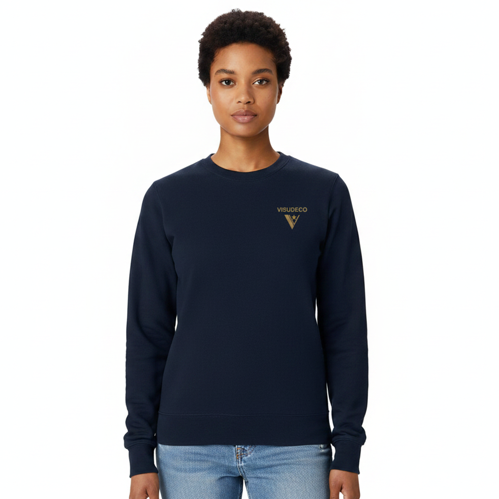 A woman modeling a navy blue crewneck sweatshirt with a gold VISUDECO logo on the left chest, paired with light blue jeans against a plain white background.