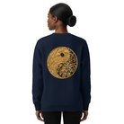 Person wearing a navy blue sweatshirt with a gold yin yang design on the back against a white background