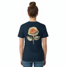 Woman wearing a navy blue t-shirt with a floral design on the back.